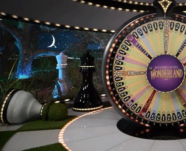 The adventures beyond wonderland live money wheel with number, Mystery and WonderSpins segments beside giant chess pieces in the studio