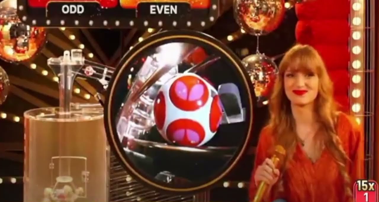 A disco balls live round with the ball drawing machine, a drawn ball in close-up, the host and the Odd and Even bet panels