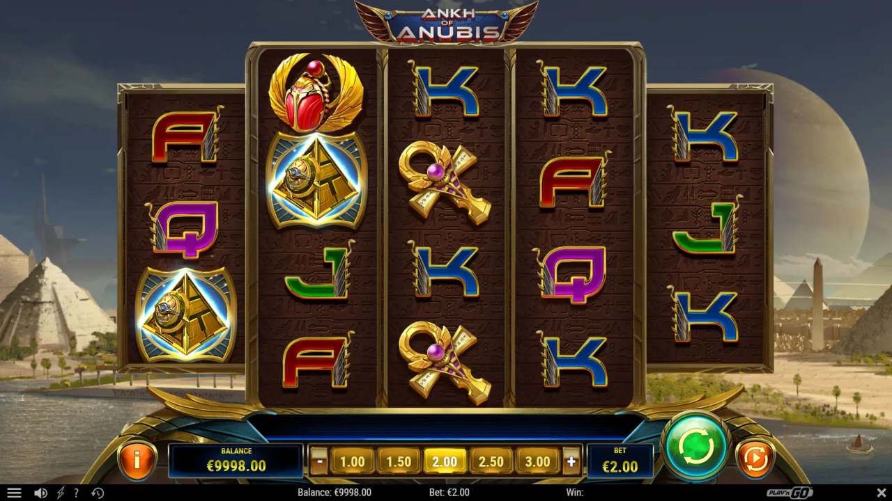 An Egyptian themed slot grid with scarab, pyramid and ankh symbols above the bet controls, set against pyramids and the Nile
