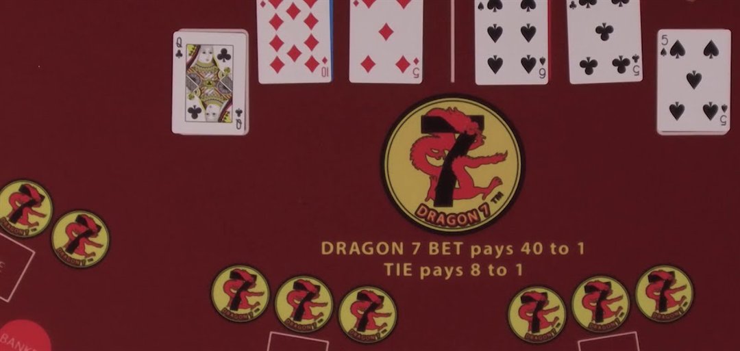 An EZ baccarat felt with player and banker cards above the Dragon 7 logo, Dragon 7 bet pays 40 to 1 and Tie pays 8 to 1