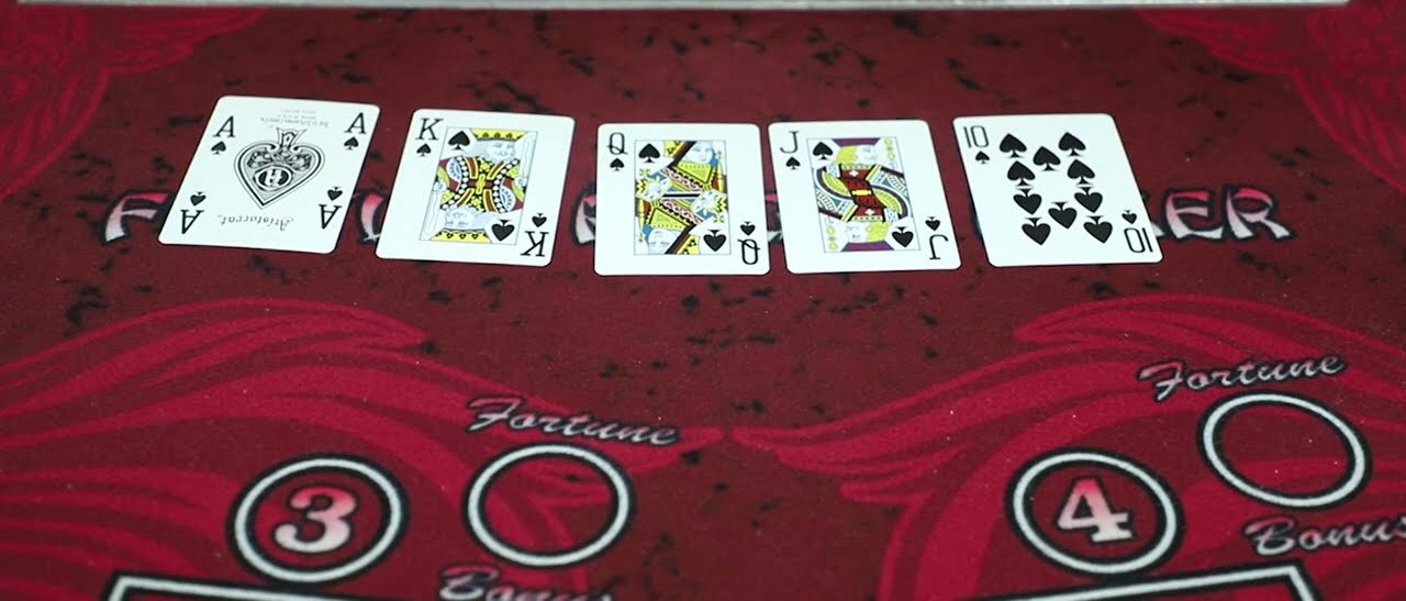 A Fortune pai gow poker table with a royal flush dealt above the Fortune and Bonus betting circles