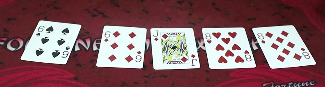 Five cards showing two pair of sixes and eights with a jack on a pai gow poker layout