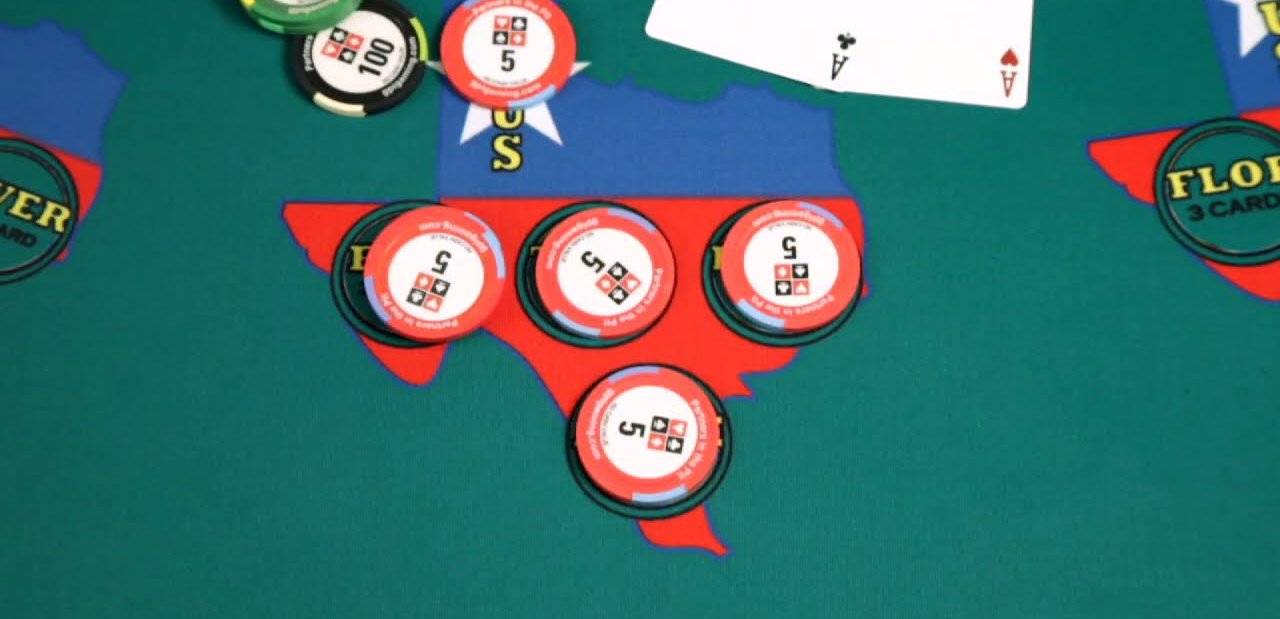 Chips placed on the Ante, Flop, Turn and River circles inside a Texas shaped texas holdem bonus poker betting zone