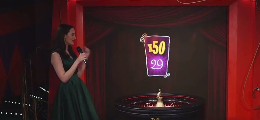Ultimate Roulette live presenter beside the wheel under a 50x multiplier card on number 29