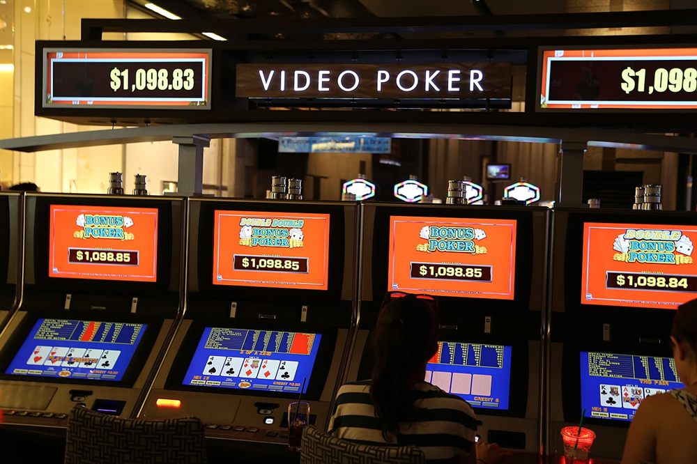 Video poker machines showing Bonus Poker pay tables and dealt hands