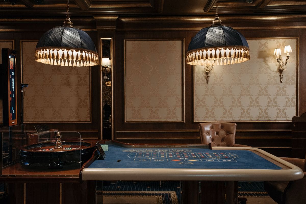 Roulette table under fringed lamps in a wood-panelled casino room, the setting behind a 400 deposit bonus casino Canada offer