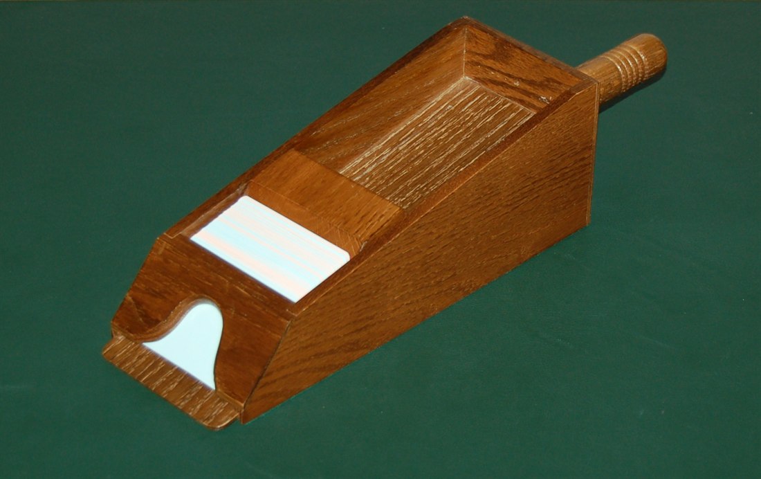 Wooden blackjack dealing shoe on green felt