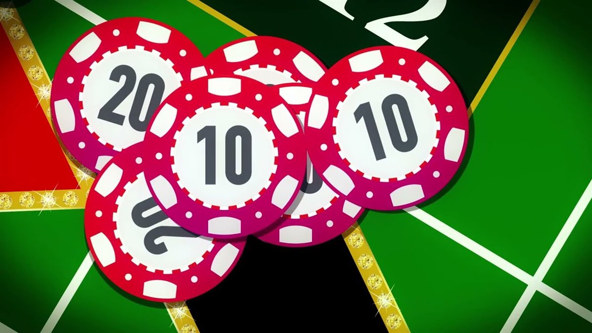 Red casino chips stacked on a green roulette layout