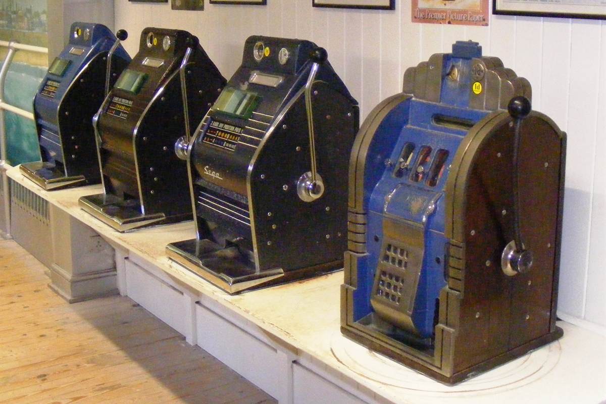 Row of four vintage one-armed bandit slot machines with side levers