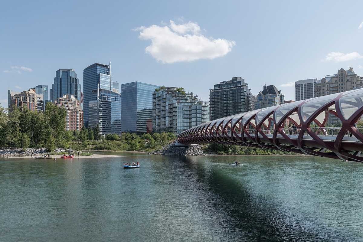 Red Peace Bridge over the Bow River with downtown Calgary towers behind