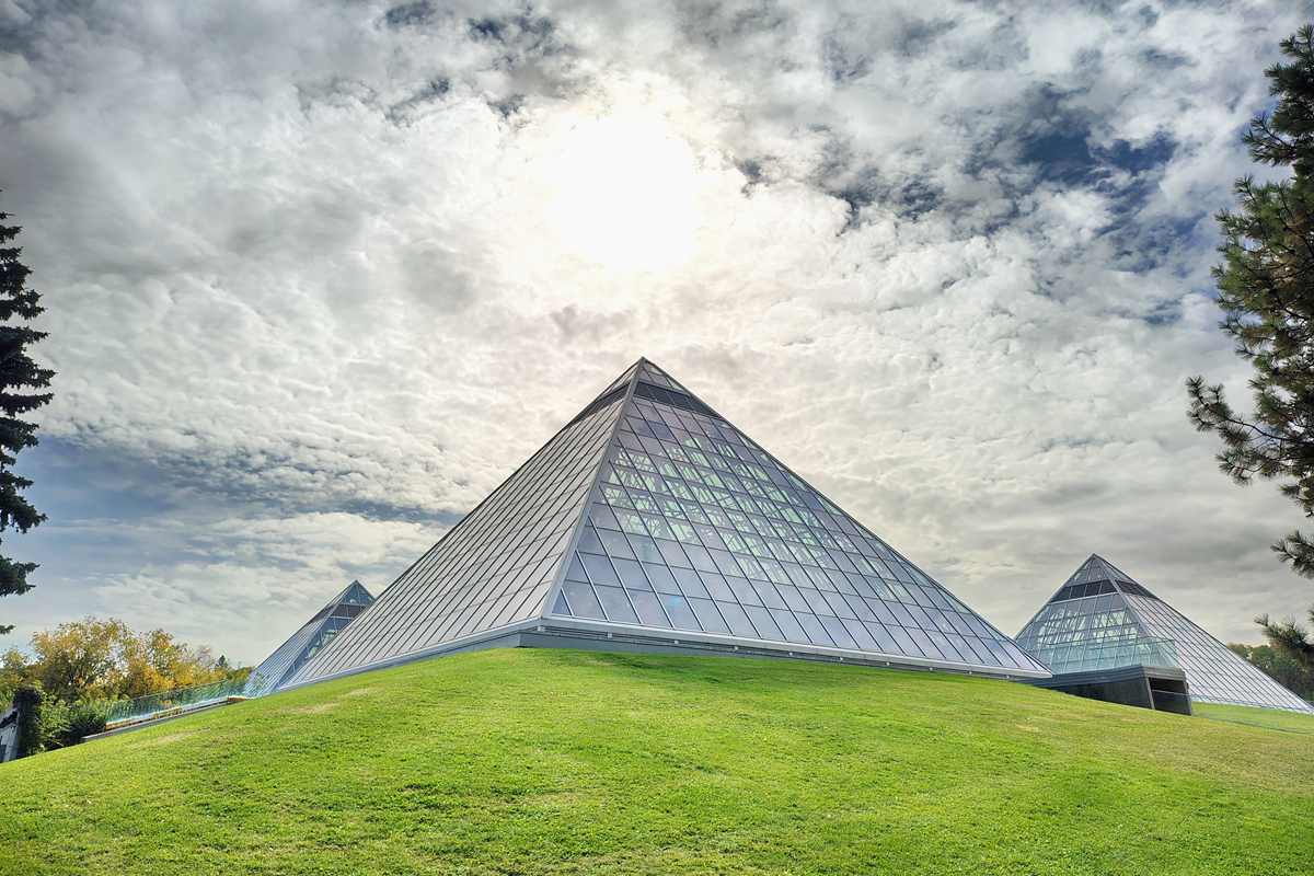 Three Muttart Conservatory glass pyramids in Edmonton under a dramatic sky