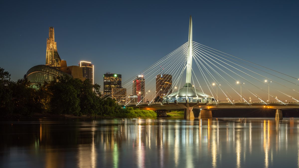 Esplanade Riel bridge over the Red River at dusk with downtown Winnipeg behind, home city of online casino Winnipeg players