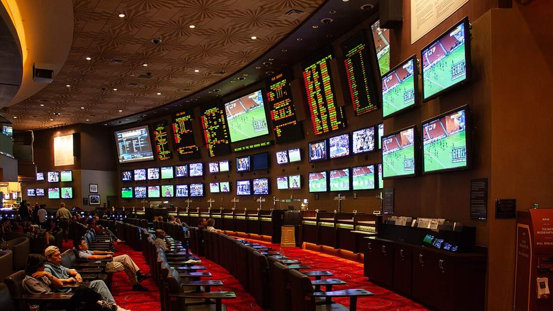 Rows of screens and odds boards in a sportsbook, where the parlay betting system Canada bettors use is built leg by leg