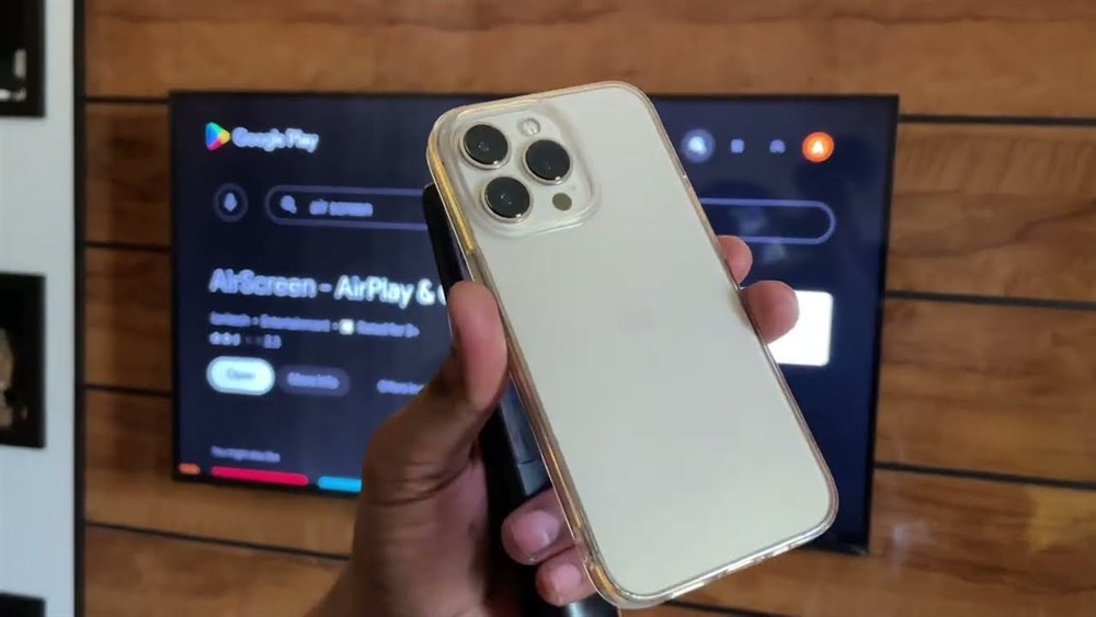 iPhone held in front of a smart TV showing a screen mirroring app, a common route to smart TV casino sites Canada players use