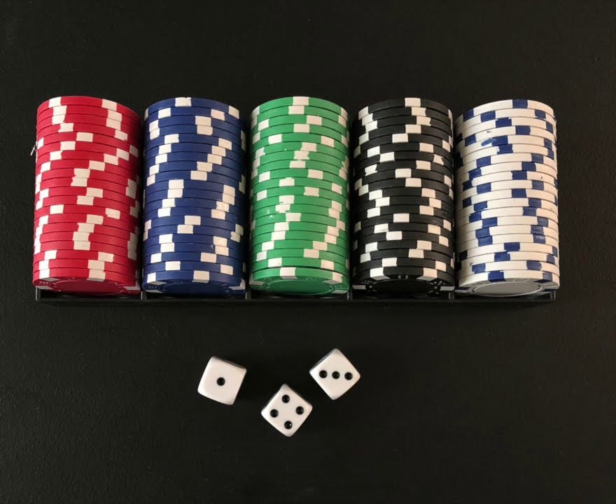 Three dice in front of casino chip stacks, ready for a round of street craps and cee-lo Canada style